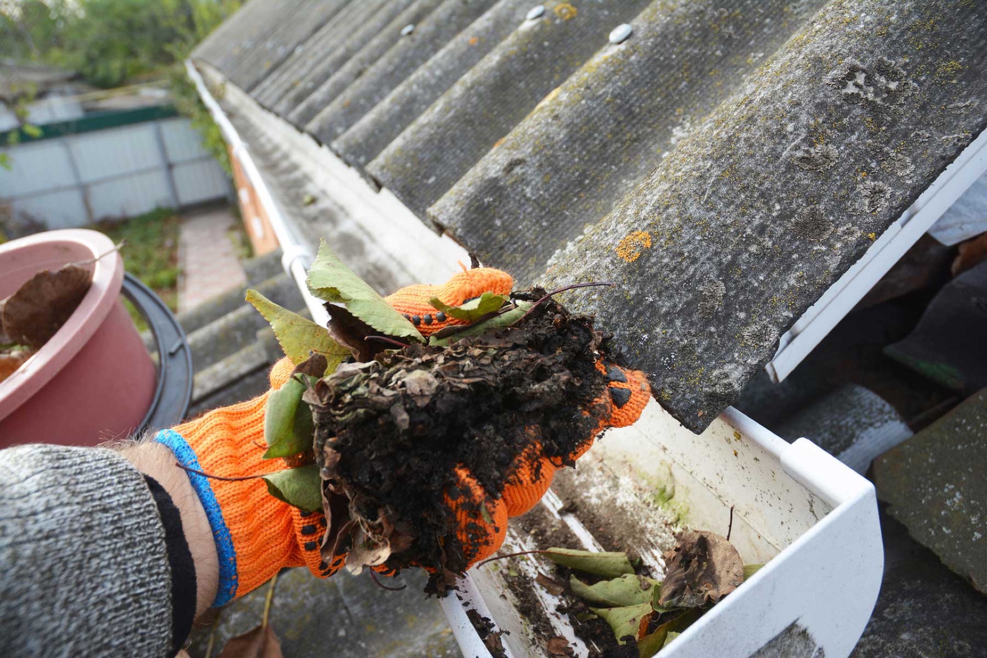 Cleaning leaves and debris from residential gutters
